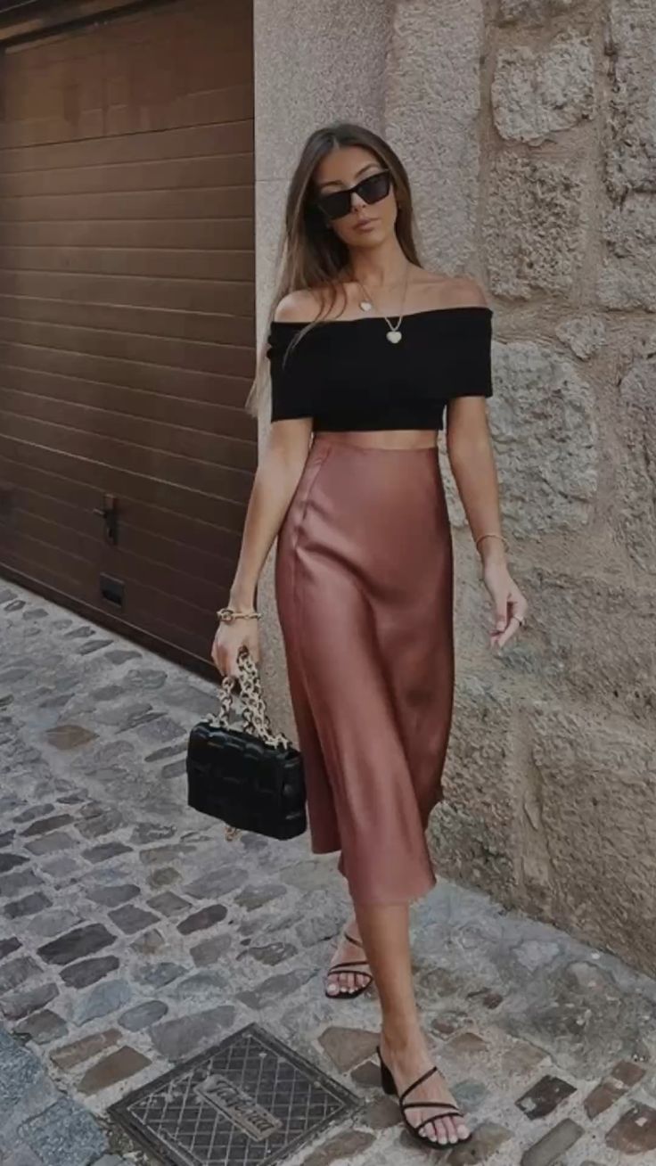 Black off-shoulder crop top with a bronze silk midi skirt